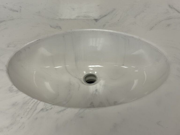 oval cast marble sink integrated into cast marble countertop